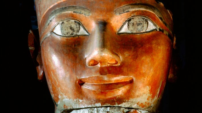 Büste der pharaonin Hatschepsut. Auf dem Foto ist lediglich die Augenpartie, die Nase und der lächelnde Mund zu sehen.