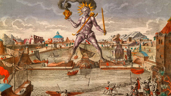 Historische Zeichnung des Koloss von Rhodos. Eine riesige Statue mit einem brennenden Gefäß in der rechten Hand steht breitbeinig über einer Hafeneinfahrt von Rhodos.