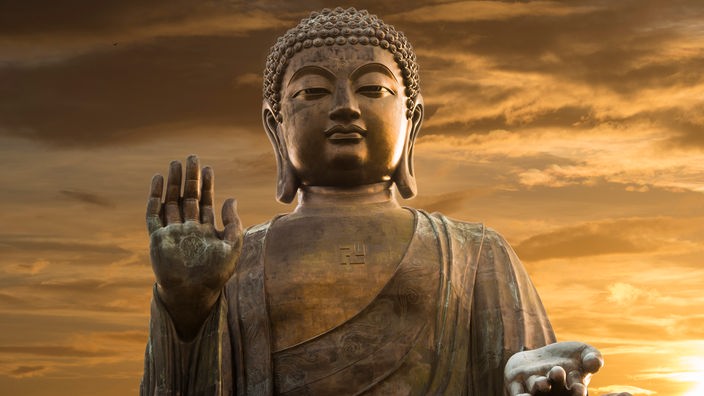 Buddhastatue aus Stein mit eiiner erhobenen rechten Hand