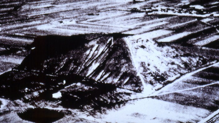 Schwarzweiß-Aufnahme aus der Luft: Zu sehen ist eine Erhöhung in der Landschaft, die pyramidenförmig ist