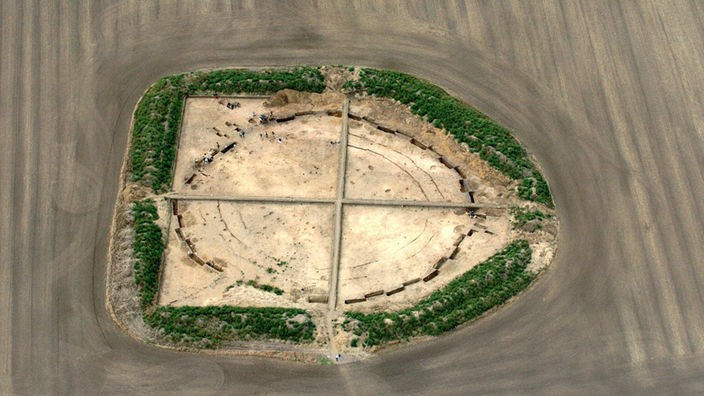 Luftbild: Ein Fundament in einem Feld, umgeben von einem bewachsenen Erdwall