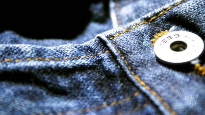 Detail einer blauen Jeans mit Metallknopf