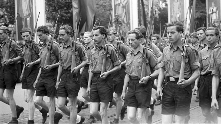Junge Männer der Freien Deutschen Jugend (FDJ) marschieren mit Gewehren (1952) | Bildquelle: akg-images / Sammlung Berliner V Junge Männer der Freien Deutschen Jugend (FDJ) marschieren mit Gewehren (1952)