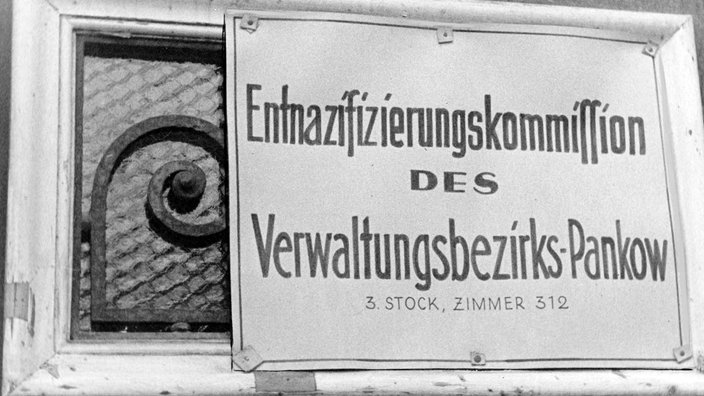 Auf einem Schild steht „Entnazifizierungskommission des Verwaltungsbezirks Pankow. 3. Stock, Zimmer 312“ | Bildquelle: Fotoarchiv für Zeitgeschichte Auf einem Schild steht „Entnazifizierungskommission des Verwaltungsbezirks Pankow. 3. Stock, Zimmer 312“