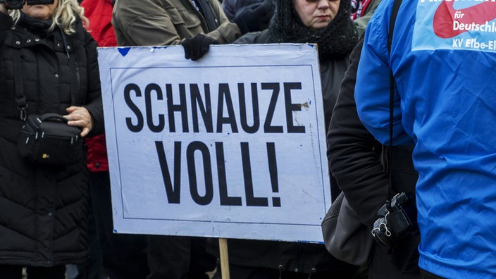 Demonstrantin mit einem Schild 'Schnauze voll'.