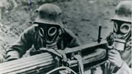 schwarz-weiß Foto zwei deutscher Soldaten mit Gasmasken an einem Maschinengewehr