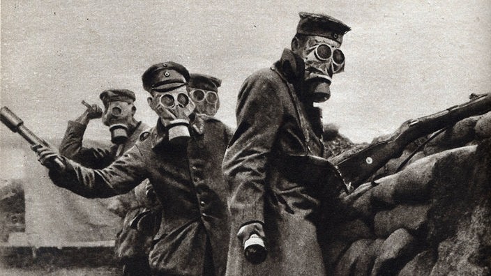 Alte Schwarzweißaufnahme: Soldaten mit Gasmasken im Ersten Weltkrieg.