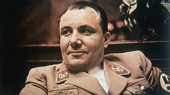 Porträt von Martin Bormann: Ein dunkelhaariger Mann Anfang 40 mit brauner NS-Uniform schaut links am Betrachter vorbei