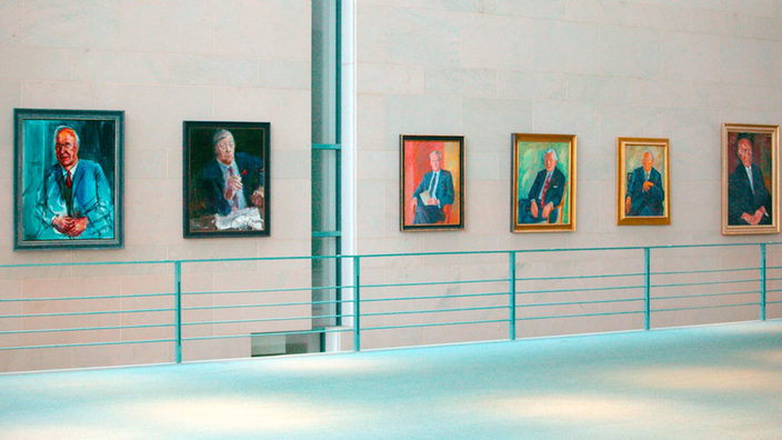 Sechs Gemälde der ehemaligen Bundeskanzler Deutschlands hängen nebeneinander an einer Wand.