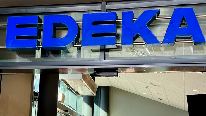 Das blaue Logo eines EDEKA-Supermarkts in Hamburg | Bildquelle: picture alliance / ABBfoto Das blaue Logo eines EDEKA-Supermarkts in Hamburg