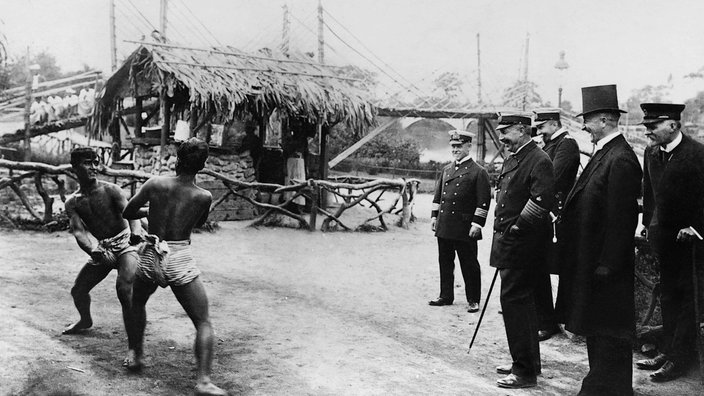Kaiser Wilhelm II. beobachtet während des Besuchs einer Völkerschau in Hagenbecks Tierpark einen Ringkampf zweier dunkelhäutiger Männer, 1913 | Bildquelle: Picture alliance / SZ Photo Kaiser Wilhelm II. beobachtet während des Besuchs einer Völkerschau in Hagenbecks Tierpark einen Ringkampf zweier dunkelhäutiger Männer, 1913