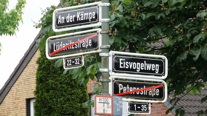 Die Straßenschilder "Lüderitzstraße" und "Petersstraße" in Düsseldorf sind durchgestrichen und durch andere Namen ersetzt | Bildquelle: picture alliance / FotoMedienService Die Straßenschilder "Lüderitzstraße" und "Petersstraße" in Düsseldorf sind durchgestrichen und durch andere Namen ersetzt
