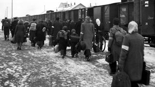 Flüchtlinge vor Eisenbahnwaggons