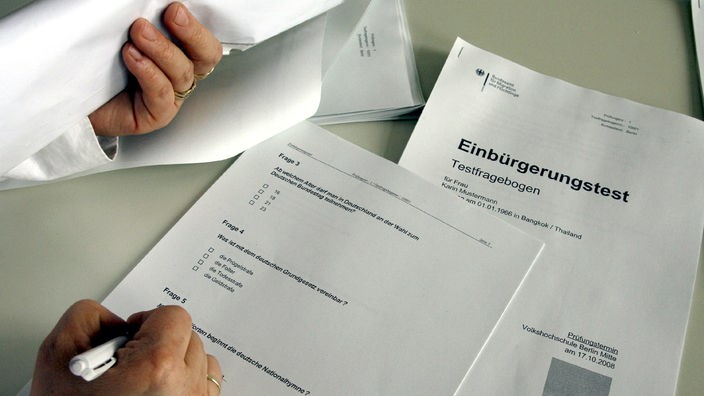 Person füllt den deutschen Einbürgerungstest aus.