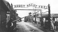 Eingang zum KZ Auschwitz mit der Aufschrift "Arbeit macht fre" (schwarz-weiß)