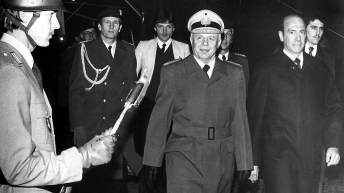 General Kießling und rechts neben ihm der damalige Verteidigungsminister Manfred Wörner laufen nebeneinander an einem Soldaten vorbei.