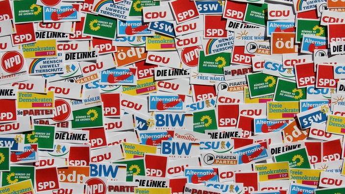 Viele verschiedene Aufkleber von deutschen Parteien, unter anderem von der CDU, SPD, Bündnis90/Die Grünen, Die Linke, AfD und Die Partei. 