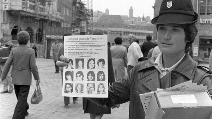 Eine Polizistin hält ein Fahndungsblatt. | Bildquelle: dpa Eine Polizistin hält ein Fahndungsblatt.