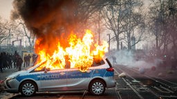 Ein brennendes Polizeiauto.