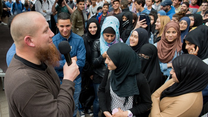 Ein radikaler Salafistenprediger spricht bei einer Kundgebung. | Bildquelle: WDR/dpa Ein radikaler Salafistenprediger spricht bei einer Kundgebung.