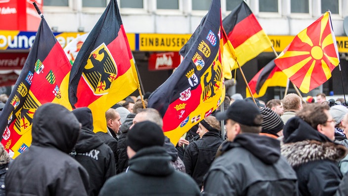 Demonstration mit schwarz gekleideten Trägern von Fahnen mit deutschen Symbolen. | Bildquelle: Mauritius images Demonstration mit schwarz gekleideten Trägern von Fahnen mit deutschen Symbolen.