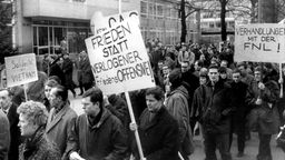 Schwarzweiß-Foto: Studenten demonstrieren mit Plakaten gegen den Vietnamkrieg.