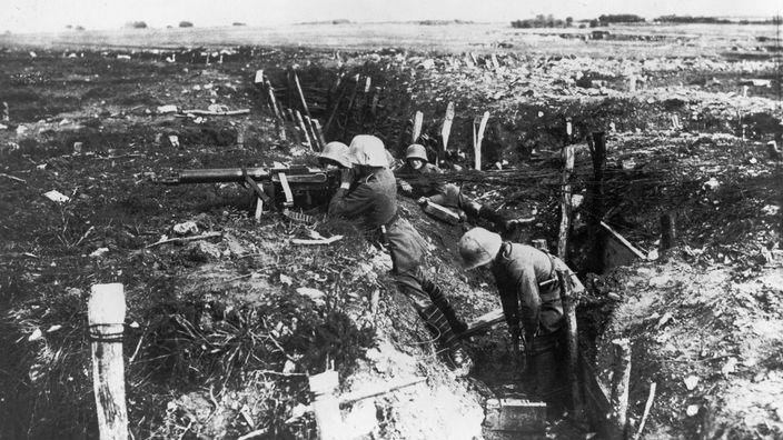 Das Schwarz-Weiß-Bild zeigt einen Schützengraben in einem zerschossenen Landstrich
