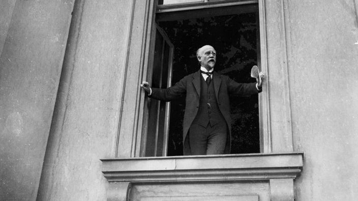 Philipp Scheidemann hält eine Rede an einem offenen Fenster.