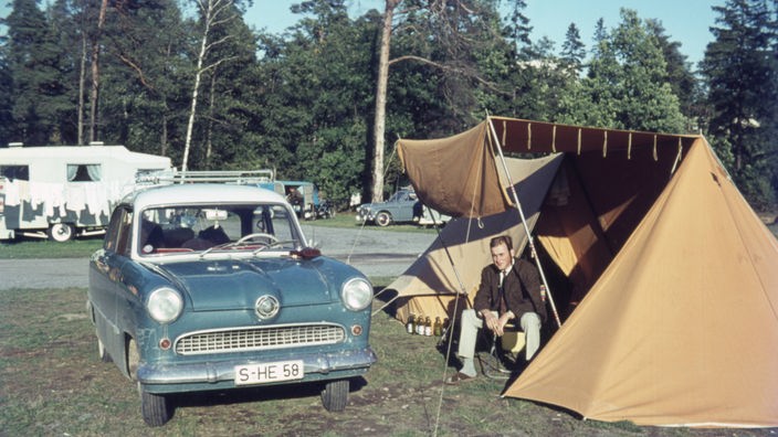 Alter Wagen steht neben einem Zelt auf einem Campingplatz, Aufnahme von 1962