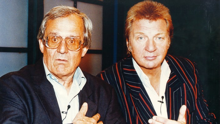 Das Foto zeigt die Kabarettisten Werner Schneyder und Dieter Hildebrandt in Porträtansicht.