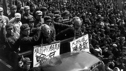 Rotgardisten fahren im Februar 1967 im offenen Wagen Menschen vor, die öffentlich als Staatsfeinde diskreditiert werden. Die Opfer müssen Spitzhüte mit ihrem Namen tragen.