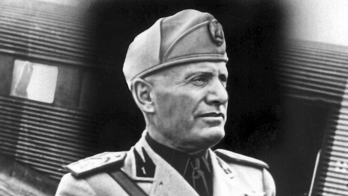 Mussolini in Militäruniform und Mütze.