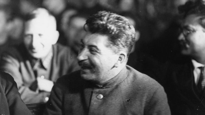 Schwarzweiß-Foto: Stalin sichtlich gut gelaunt und lachend.
