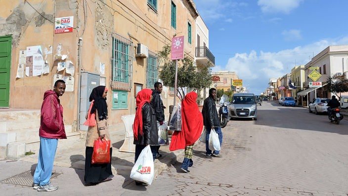 Eine Gruppe von Flüchtlingen läuft auf einer Straße.