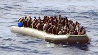 Viele Flüchtlinge auf engem Raum in einem Boot auf dem Weg über das Mittelmeer.