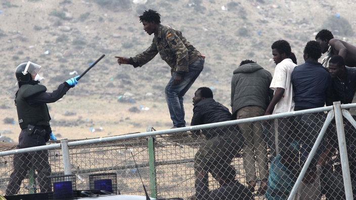 Flüchtlinge geraten in Kontakt mit Grenzpolizisten. | Bildquelle: ap Flüchtlinge geraten in Kontakt mit Grenzpolizisten.