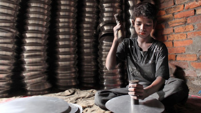 Ein Junge arbeitet in einer Aluminiumfabrik in Bangladesh