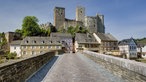 Blick über eine alte Brücke auf Häuser und die Burg Runkel