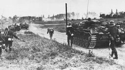 Schwarz-weiß-Bild: Deutsche Panzer und Soldaten auf dem Weg nach Polen.