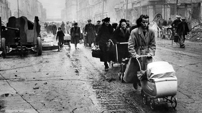 Schwarzweiß-Bild: Überlebende in einer zerstörten Stadt. | Bildquelle: Akg-Images Schwarzweiß-Bild: Überlebende in einer zerstörten Stadt.