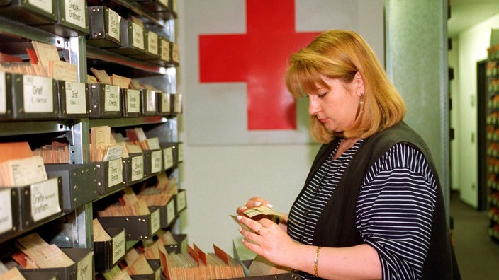 Eine Mitarbeiterin des Suchdienstes vom Deutschen Roten Kreuz (DRK) in München blättert in einem Karteikasten