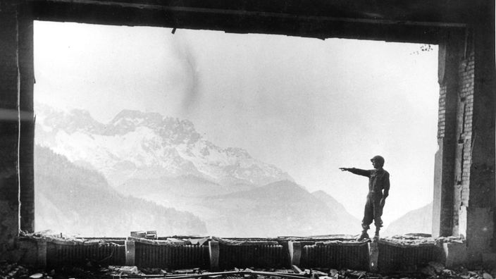 Amerikanischer Soldat im Panoramafenster des ausgebrannten Berghofes.