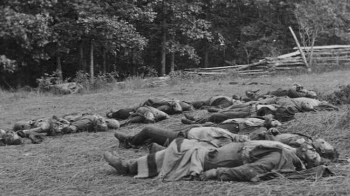 Archivfoto: Auf einem Feld liegen getötete Soldaten.