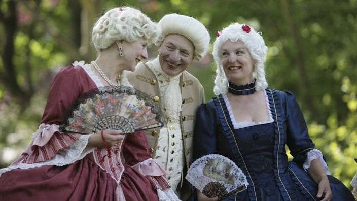 Nachgestellt: Zwei Fraeun und ein Mann in barocken Kostümen