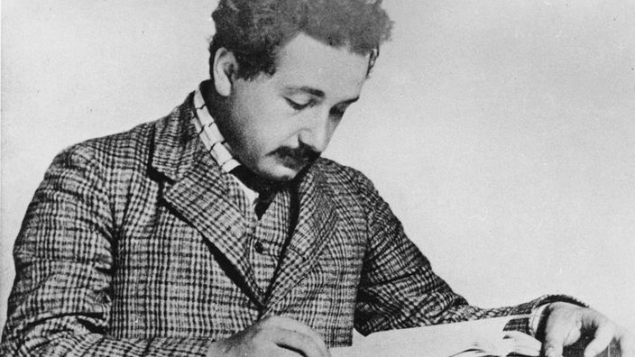 Schwatzweiß-Bild: Einstein liest im Stehen ein Buch