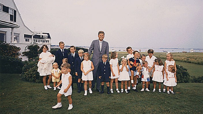 John F. Kennedy im Kreise junger Familienmitglieder vor dem Familiernanwesen in Hyannis Port