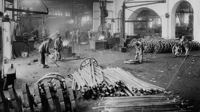 Die Räderschmiede der Gussstahlfabrik Krupp im Jahr 1900; darin Arbeiter beim Schmieden.