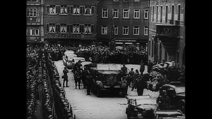 schwarz-weiß-Aufnahme vom letzten Geleit Rommels mit vielen Menschen.