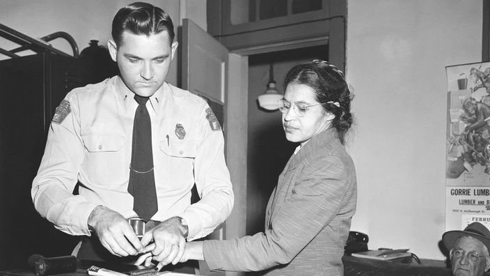 Schwarzweiß-Foto: Ein Polizeibeamter nimmt Rosa Parks die Fingerabdrücke ab
