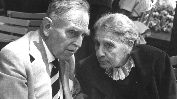 Schwarzweiß-Foto: Lise Meitner im Gespräch mit Otto Hahn.